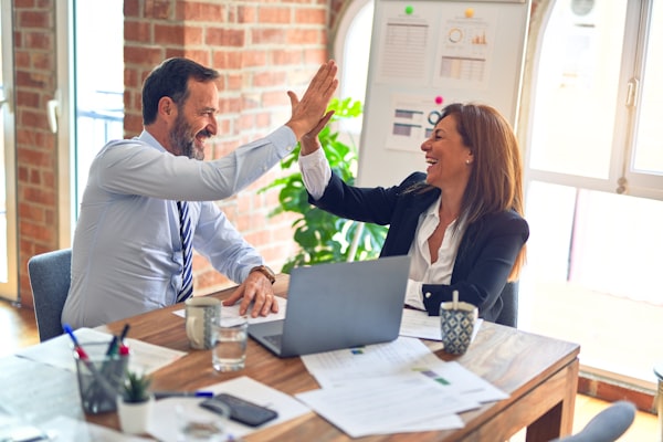 Two advisors sitting at a desk going through paperwork with a customer